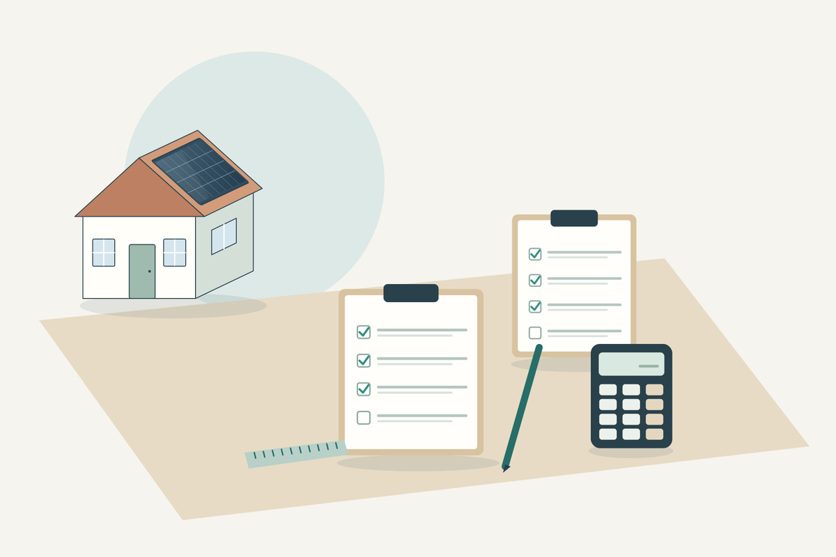 Woningmodel met zonnepanelen, twee checklists, een liniaal en een rekenmachine op een tafel.